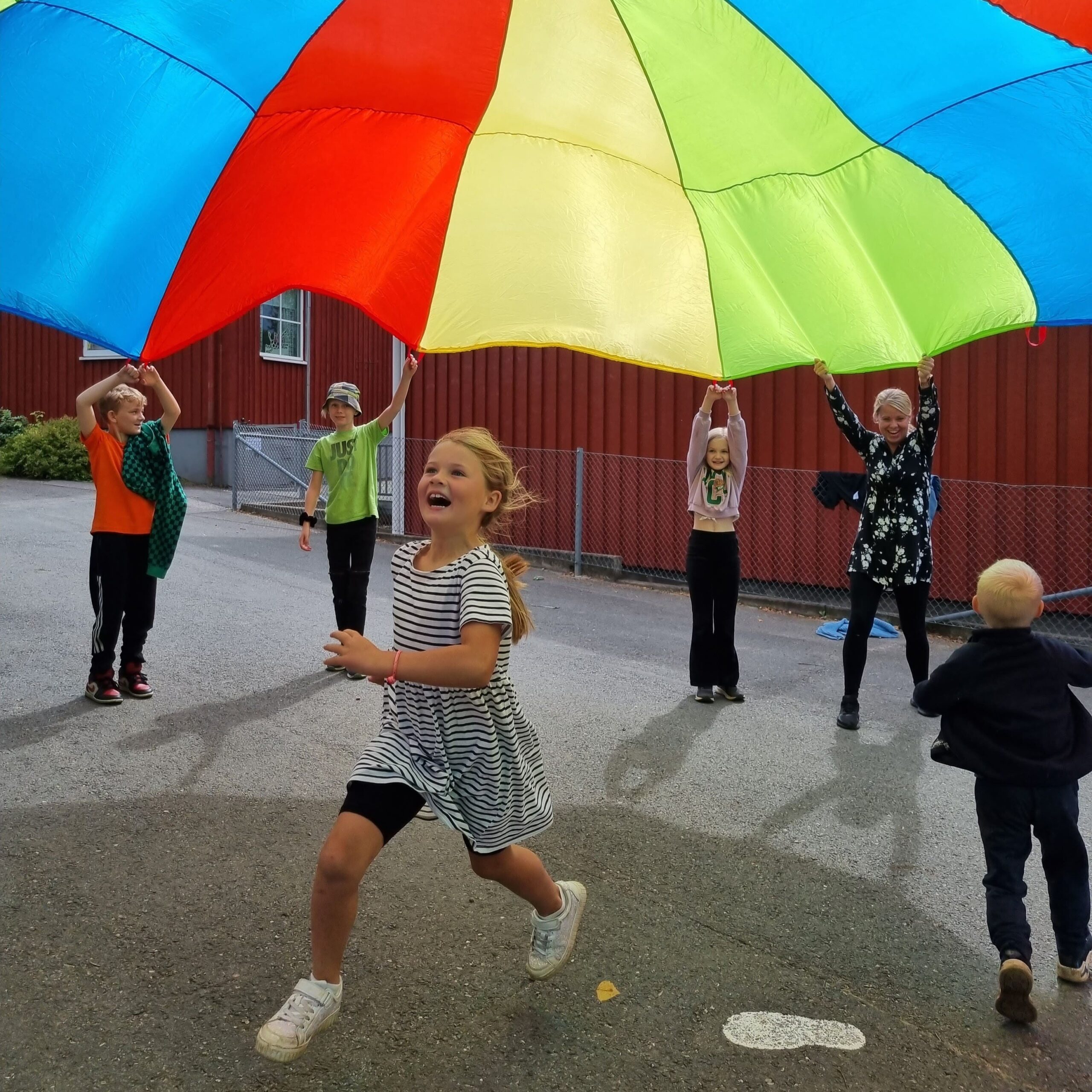 Barn som leker med fallskärmstyg